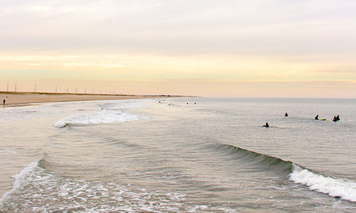 Surfers enjoying the waves at Delaware Seashore State Park