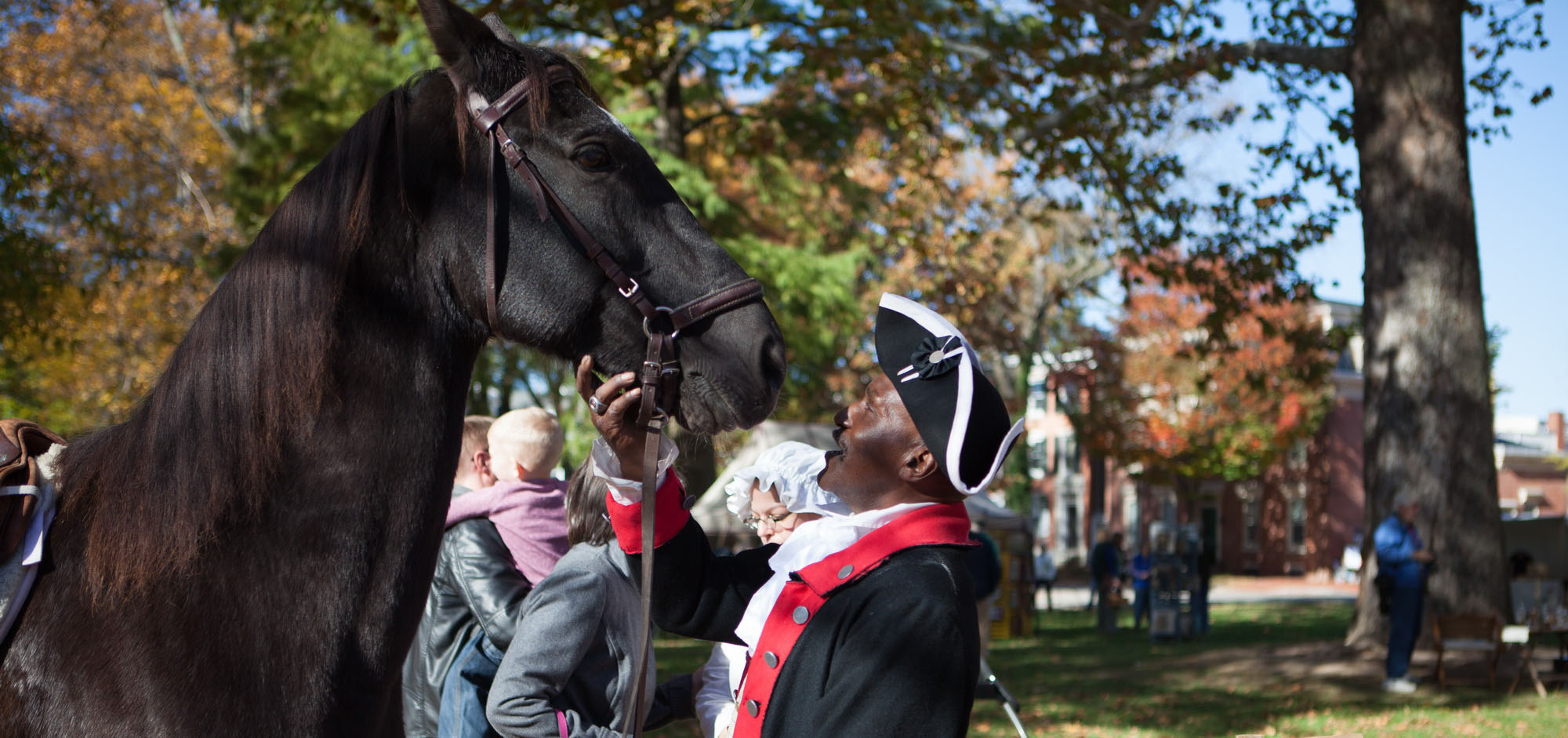 Man in colonial costume talks to his horse at Market Fair takes place each November